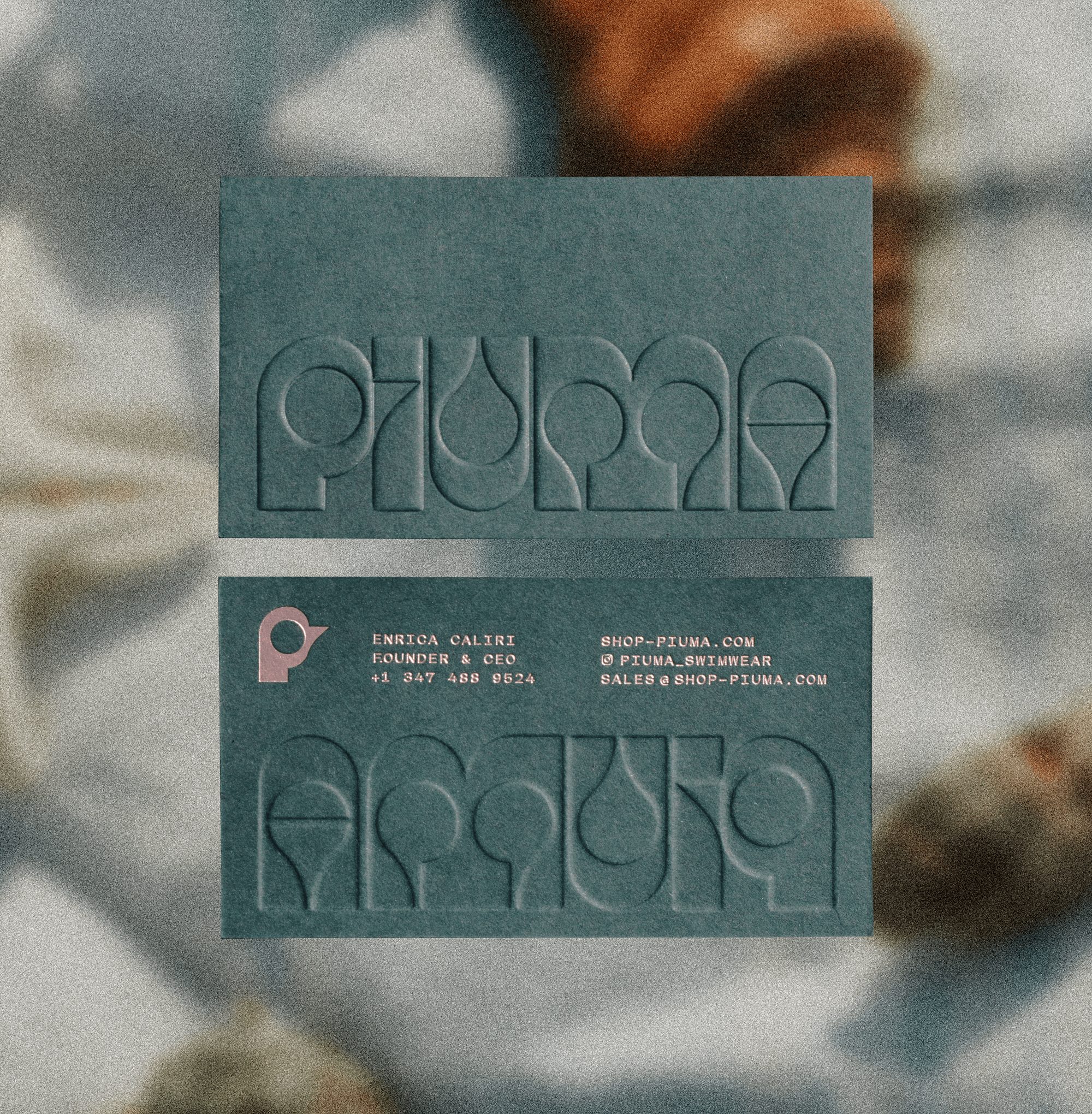 Embossed Piuma business cards featuring the geometric wordmark
