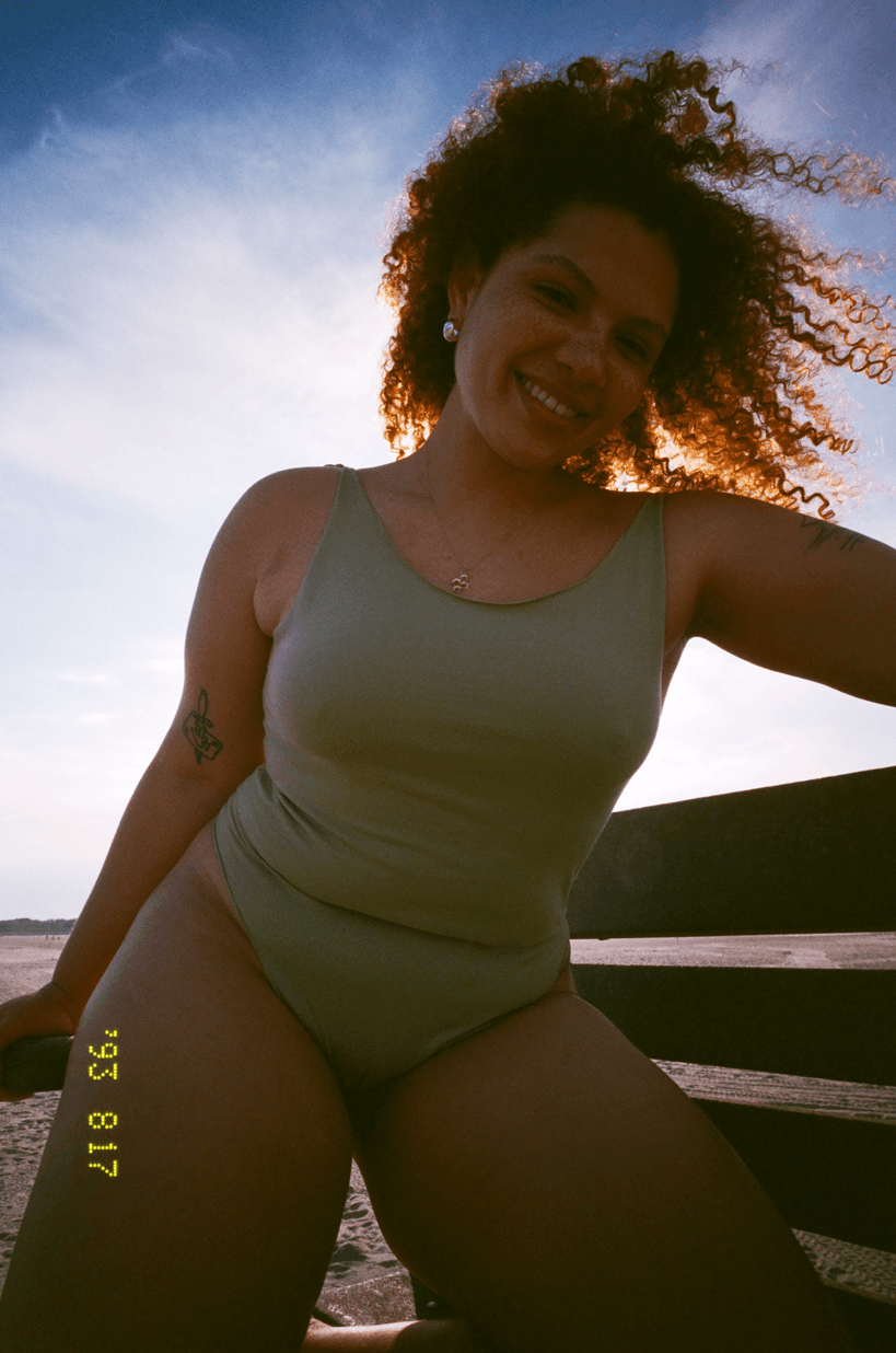 Piuma campaign portrait of a model in a green swimsuit outdoors