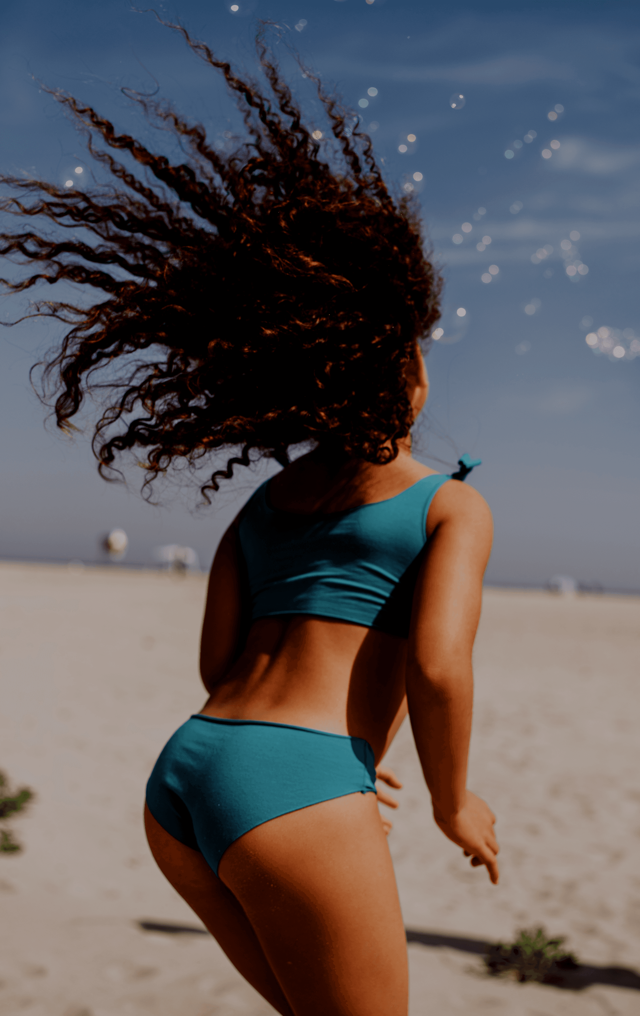 Piuma campaign photograph of a model walking along the beach