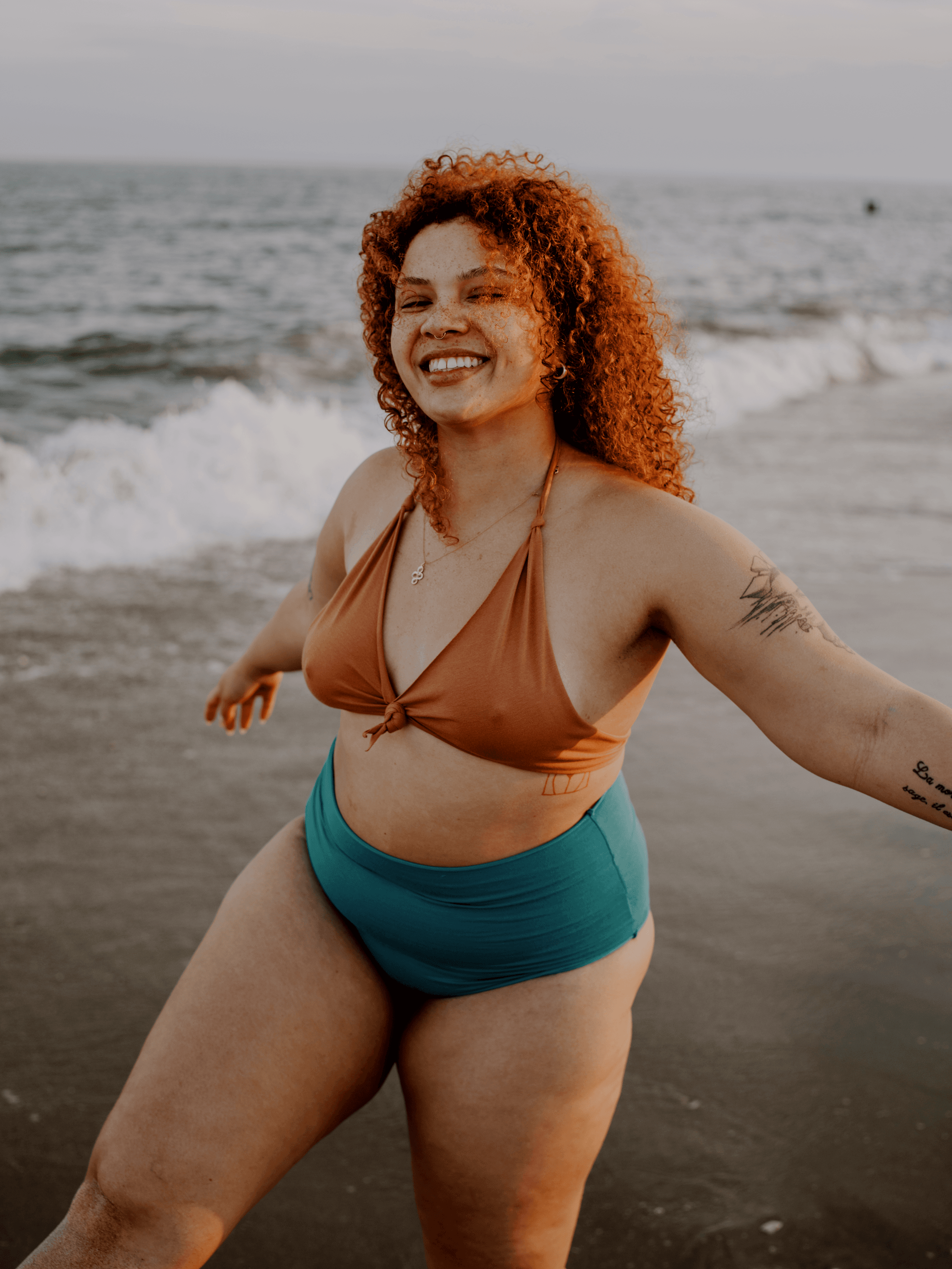 Piuma campaign portrait of a model in two-tone swimwear by the ocean