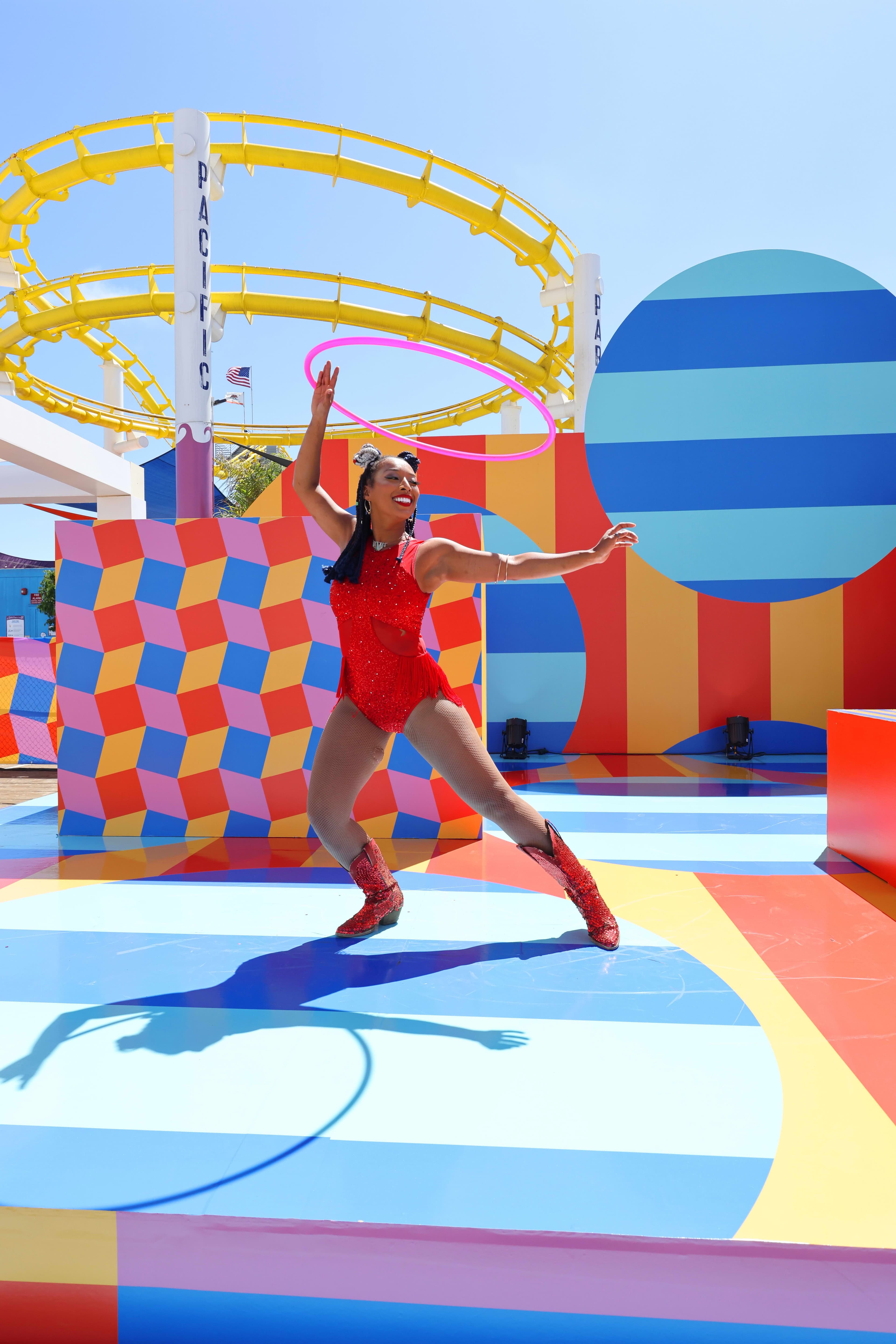 Performer with a hoop inside The Boardwalk event installation